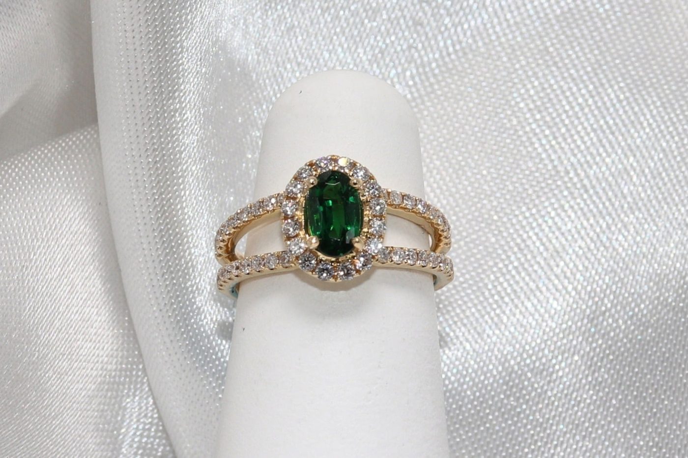 Original counter photo of an emerald and diamond ring on a ring stand